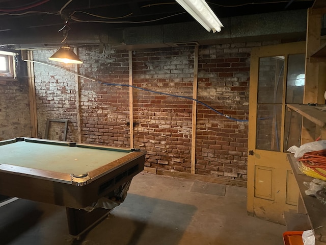 recreation room with brick wall, concrete floors, and billiards