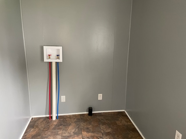 washroom with dark tile flooring and washer hookup