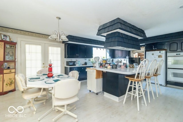 1205 Ivywood Ct, New Castle, IN 47362 - kitchen featuring an inviting chandelier, white appliances, a kitchen bar, light countertops, and french doors