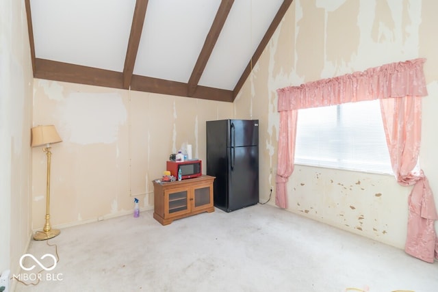 interior space with beamed ceiling, black refrigerator, high vaulted ceiling, and white cabinetry