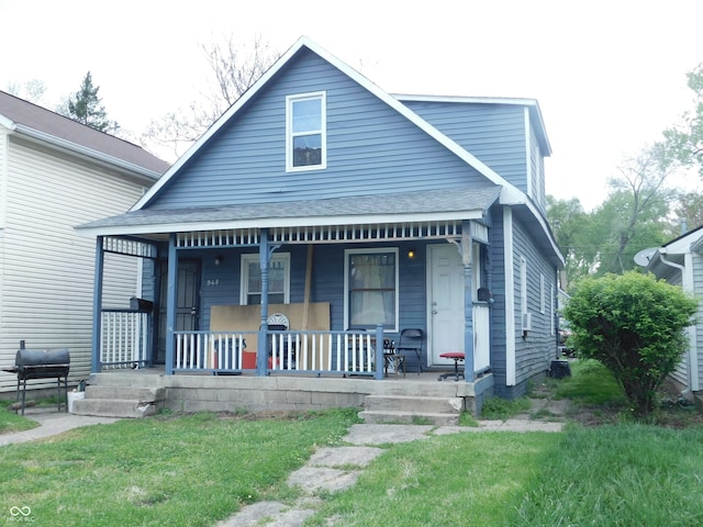 bungalow-style house featuring covered porch and a front lawn