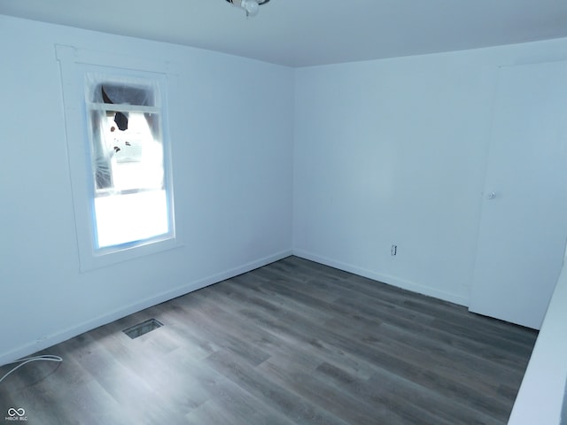 empty room with dark hardwood / wood-style flooring