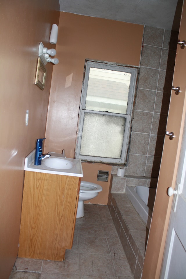 bathroom featuring vanity, toilet, a bath, and tile patterned floors