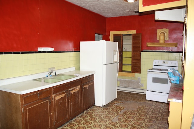 kitchen featuring backsplash, ventilation hood, sink, a textured ceiling, and white appliances