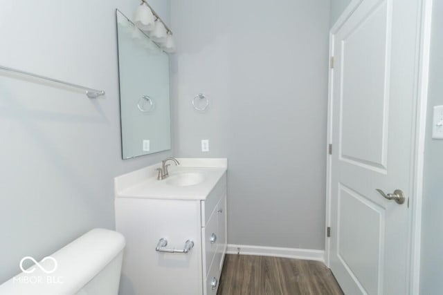 bathroom featuring vanity, wood-type flooring, and toilet