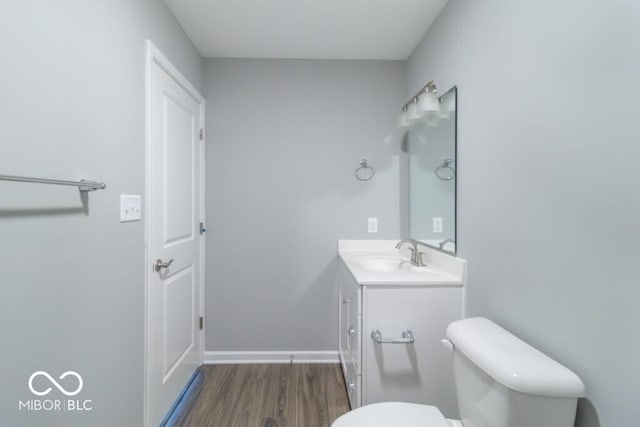 bathroom featuring hardwood / wood-style flooring, vanity, and toilet