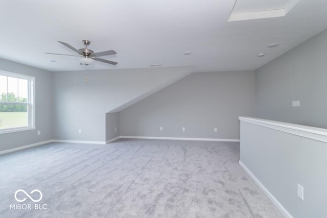 additional living space featuring ceiling fan, light colored carpet, and vaulted ceiling