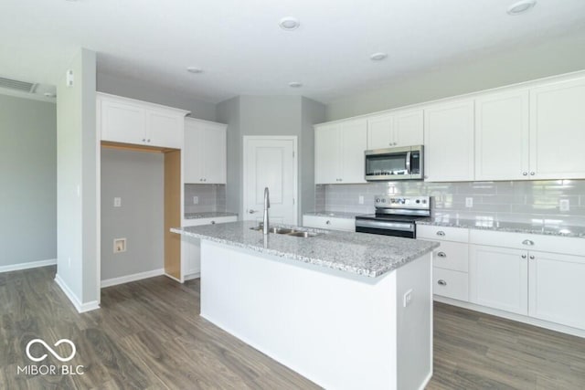 kitchen featuring a center island with sink, sink, light stone counters, white cabinetry, and stainless steel appliances