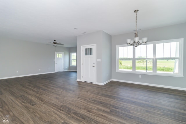 empty room with dark wood-type flooring and ceiling fan with notable chandelier