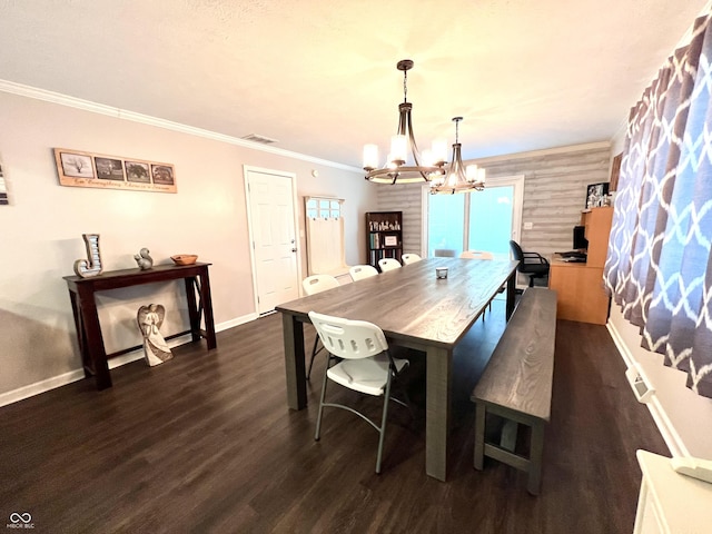 dining room featuring dark wood-style flooring, a chandelier, baseboards, visible vents, and ornamental molding