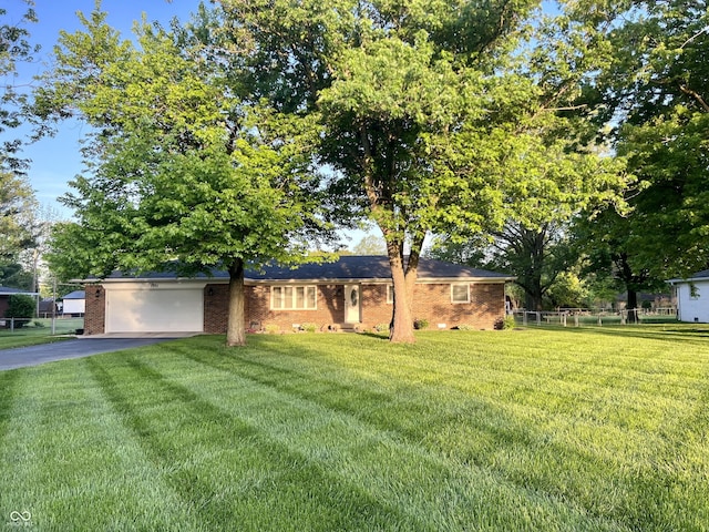 ranch-style home featuring brick siding, a front lawn, an attached garage, and driveway