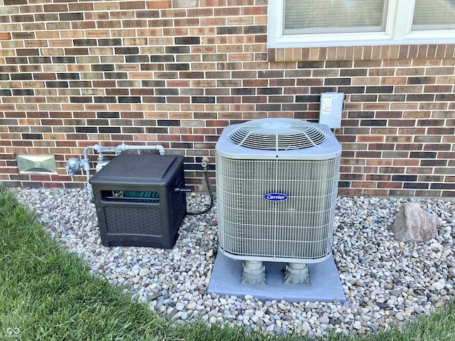 exterior details featuring brick siding, central AC, and a wood stove