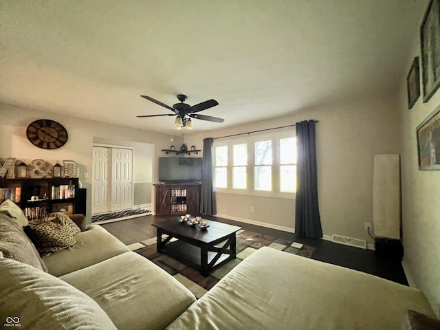 living room with baseboards, ceiling fan, dark wood-style flooring, and visible vents
