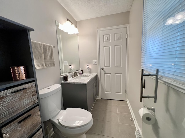 bathroom featuring toilet, a textured ceiling, tile patterned flooring, and vanity