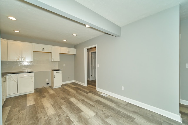 kitchen with white cabinets, backsplash, light hardwood / wood-style flooring, and beam ceiling