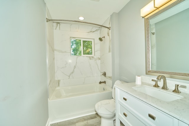 full bathroom featuring hardwood / wood-style flooring, toilet, tiled shower / bath combo, and vanity