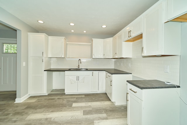 kitchen featuring tasteful backsplash, light hardwood / wood-style floors, white cabinetry, and sink