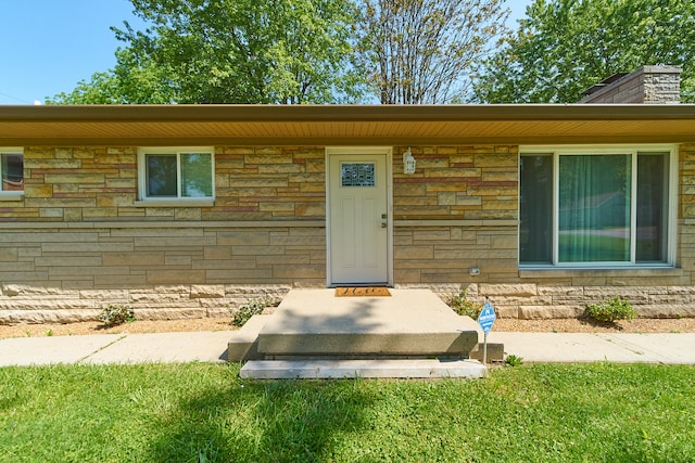 entrance to property with a lawn