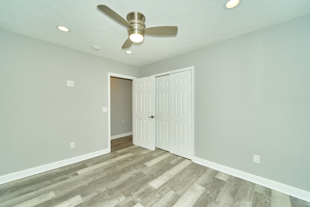 unfurnished bedroom featuring a closet, ceiling fan, and light wood-type flooring