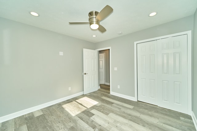 unfurnished bedroom with light hardwood / wood-style flooring, ceiling fan, and a closet