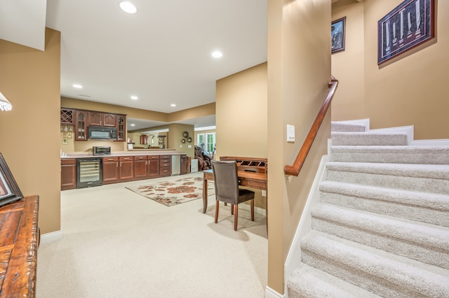 staircase with beverage cooler and light colored carpet