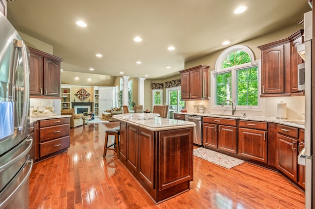 kitchen with dark wood-type flooring, a center island, stainless steel appliances, and plenty of natural light