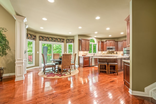 kitchen featuring ornate columns, a center island, and a healthy amount of sunlight