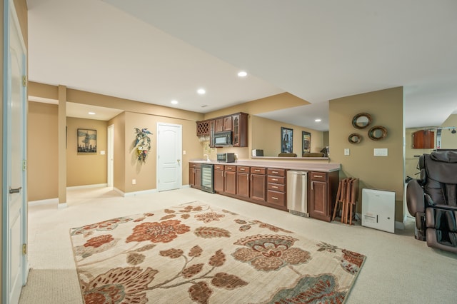 kitchen featuring dark brown cabinets, stainless steel dishwasher, and light colored carpet