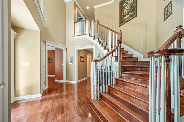 staircase with a high ceiling and dark wood-type flooring