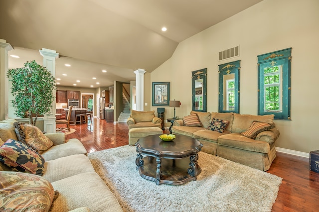 living room with lofted ceiling, a wealth of natural light, dark wood-type flooring, and decorative columns