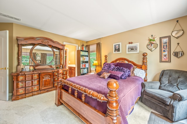 bedroom featuring ensuite bathroom and light carpet