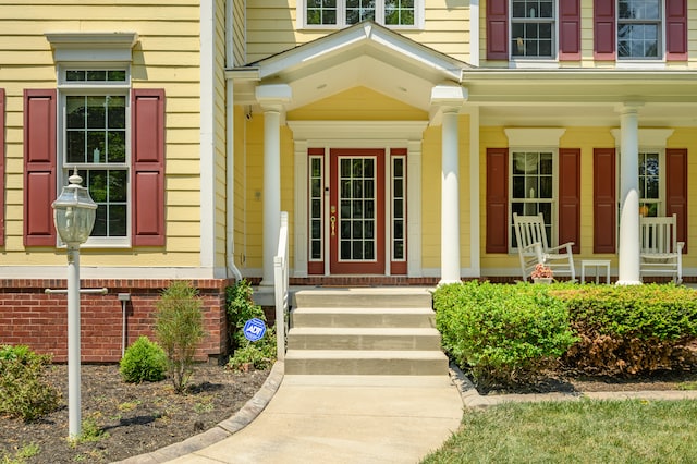 view of exterior entry featuring covered porch