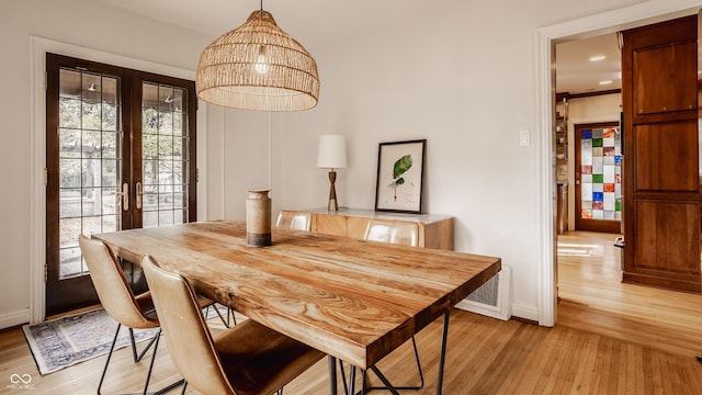 dining room with light hardwood / wood-style floors and french doors