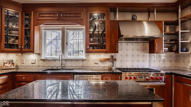 kitchen with dark stone countertops, sink, wall chimney exhaust hood, and appliances with stainless steel finishes