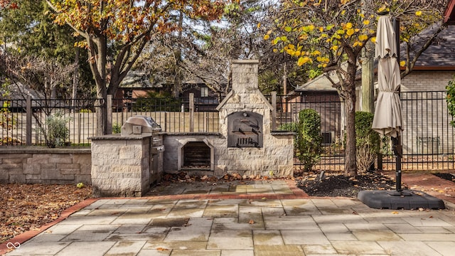 view of patio with a grill, an outdoor kitchen, and an outdoor stone fireplace