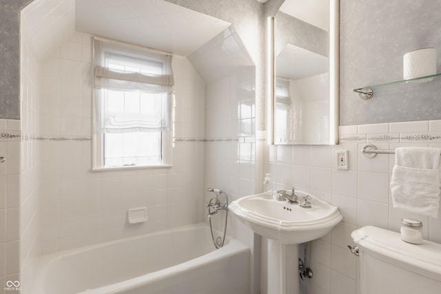 full bathroom featuring sink, toilet, tile walls, and tiled shower / bath