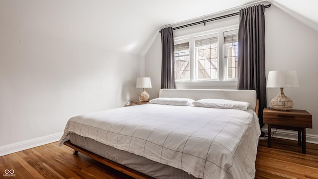 bedroom featuring wood-type flooring and vaulted ceiling