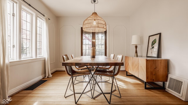 dining area featuring plenty of natural light, light wood-type flooring, and heating unit