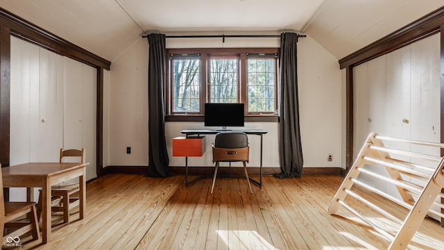 home office featuring light wood-type flooring, crown molding, and lofted ceiling