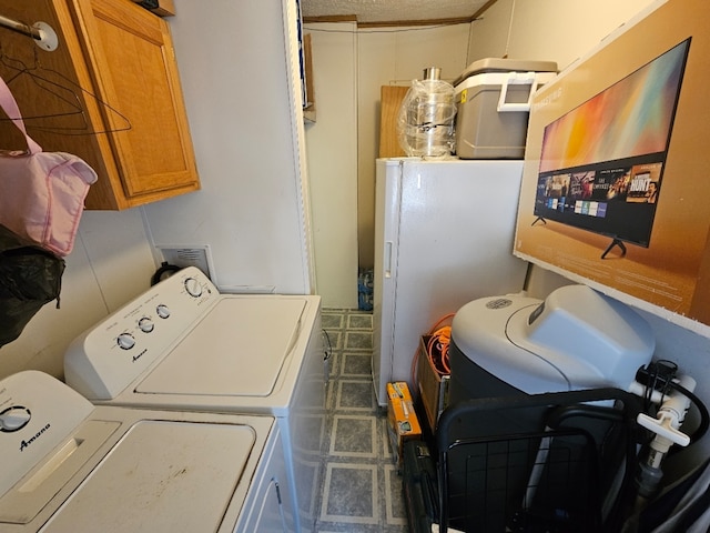 laundry area with tile flooring, cabinets, and washer and dryer