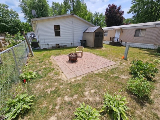 view of yard featuring a patio area, a fire pit, and a storage shed