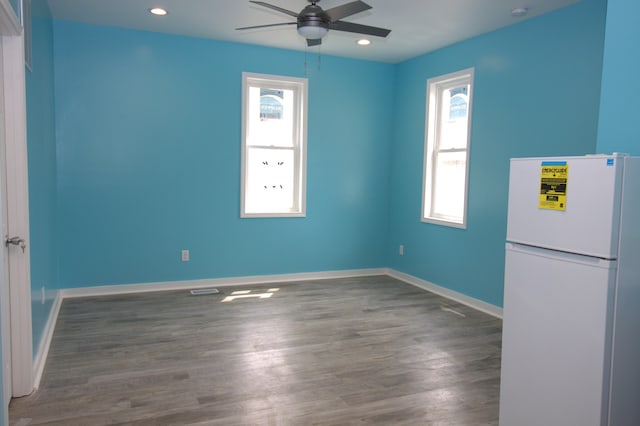 interior space with white fridge, ceiling fan, and dark hardwood / wood-style flooring