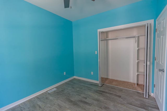 unfurnished bedroom featuring a closet, ceiling fan, and dark wood-type flooring