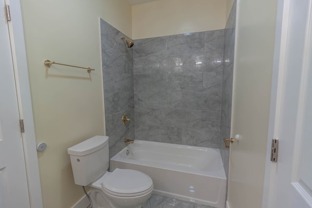 bathroom featuring tiled shower / bath combo, toilet, and tile flooring