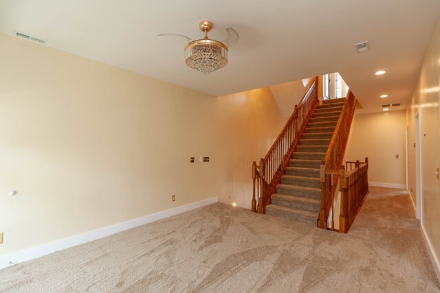 stairway featuring light colored carpet