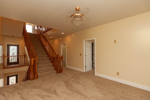 staircase with carpet floors and a chandelier