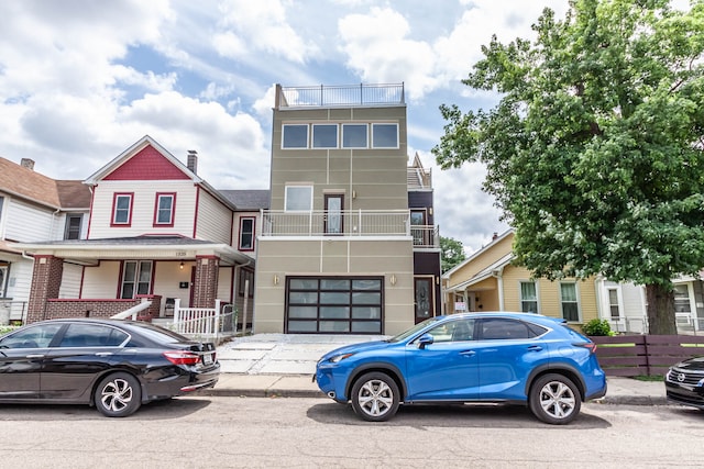 view of front of property featuring a balcony and a garage