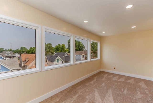 unfurnished room featuring light colored carpet