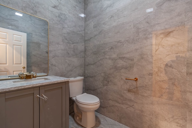 bathroom with tile walls, oversized vanity, toilet, and tile flooring