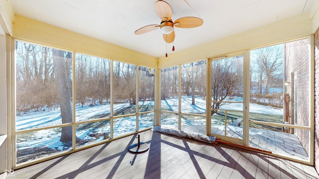 unfurnished sunroom featuring ceiling fan